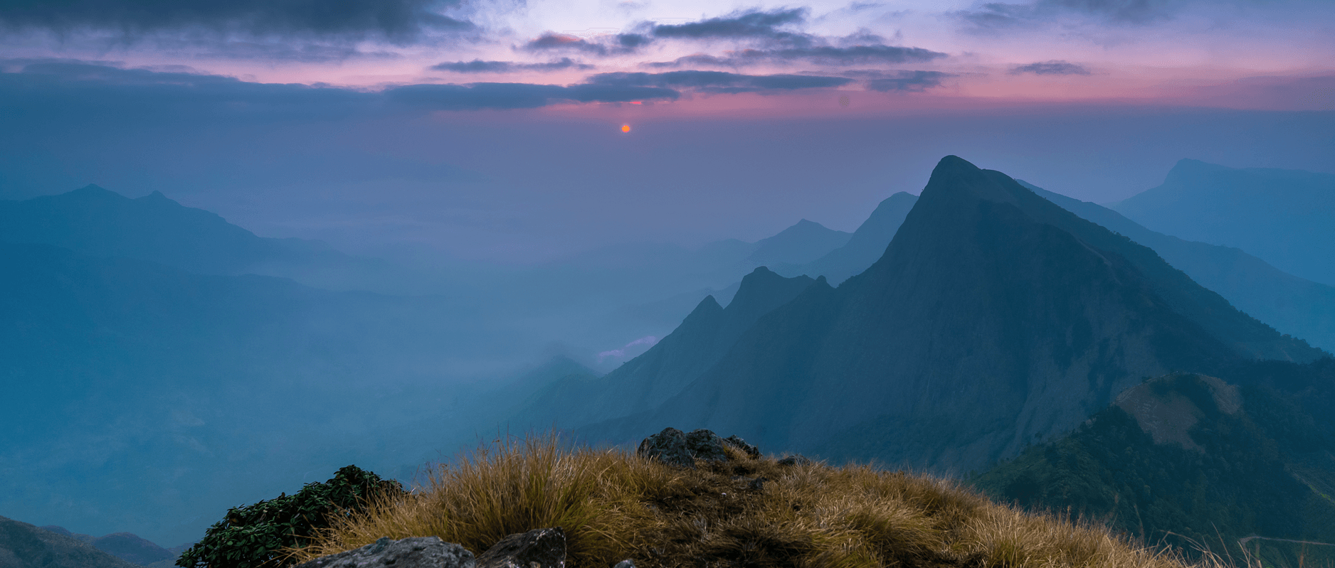 Misty mountain sunrise over layered Western Ghats ridgelines