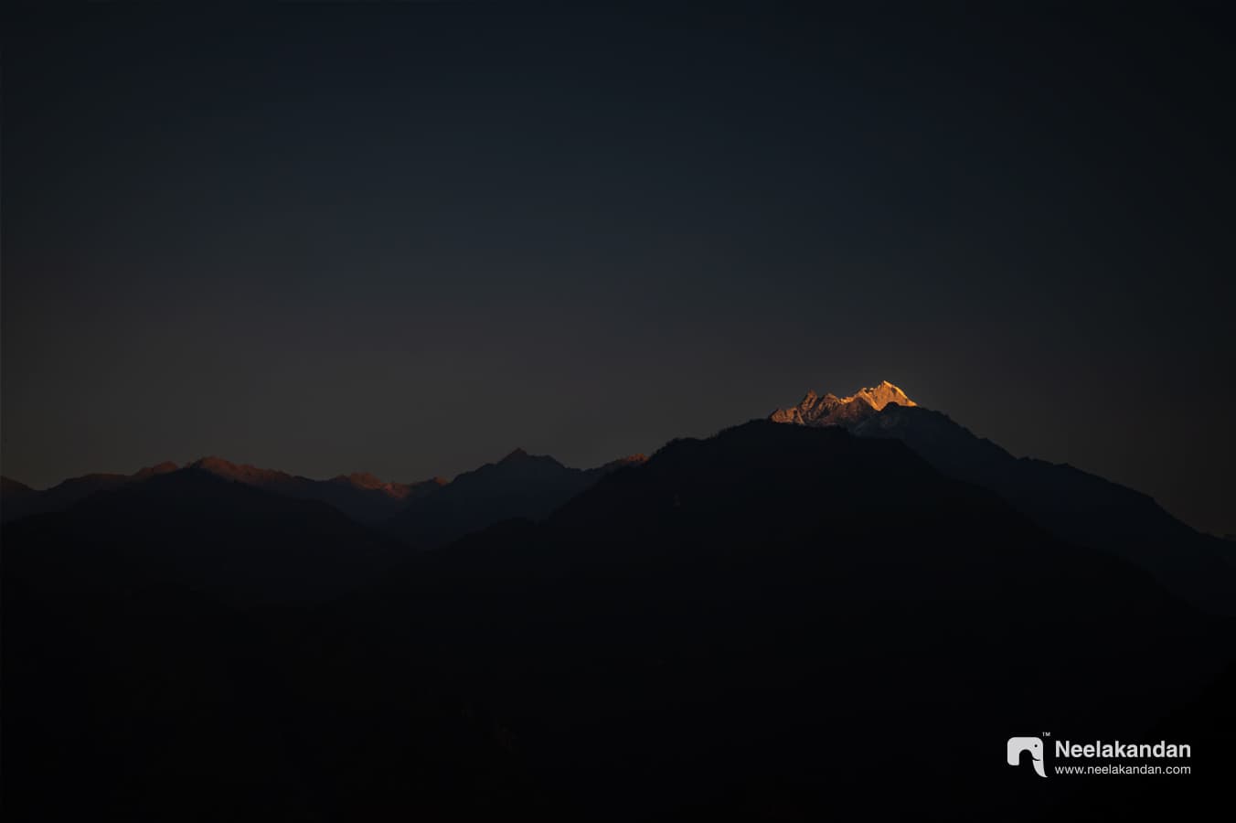 THe first rays of light hitting the snow caped mountain peak somewhere deep inside the Himalayas